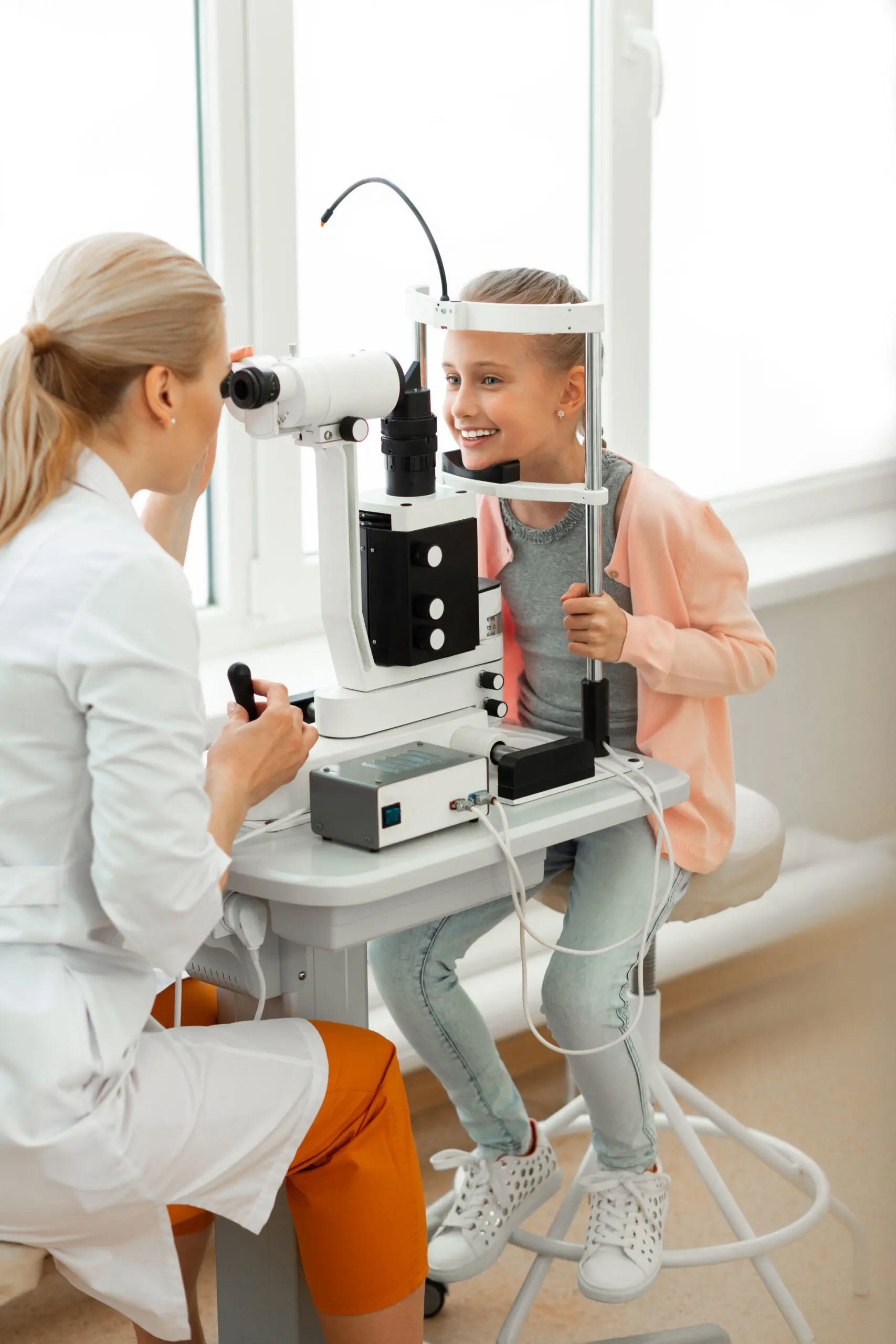Optometrist performing a comprehensive pediatric eye exam on a young child at Maple Grove Eye Doctors at Pearle Vision