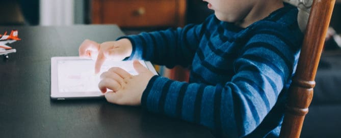 Kid Playing with a Tablet Maple Grove Eye Doctors at Pearle Vision