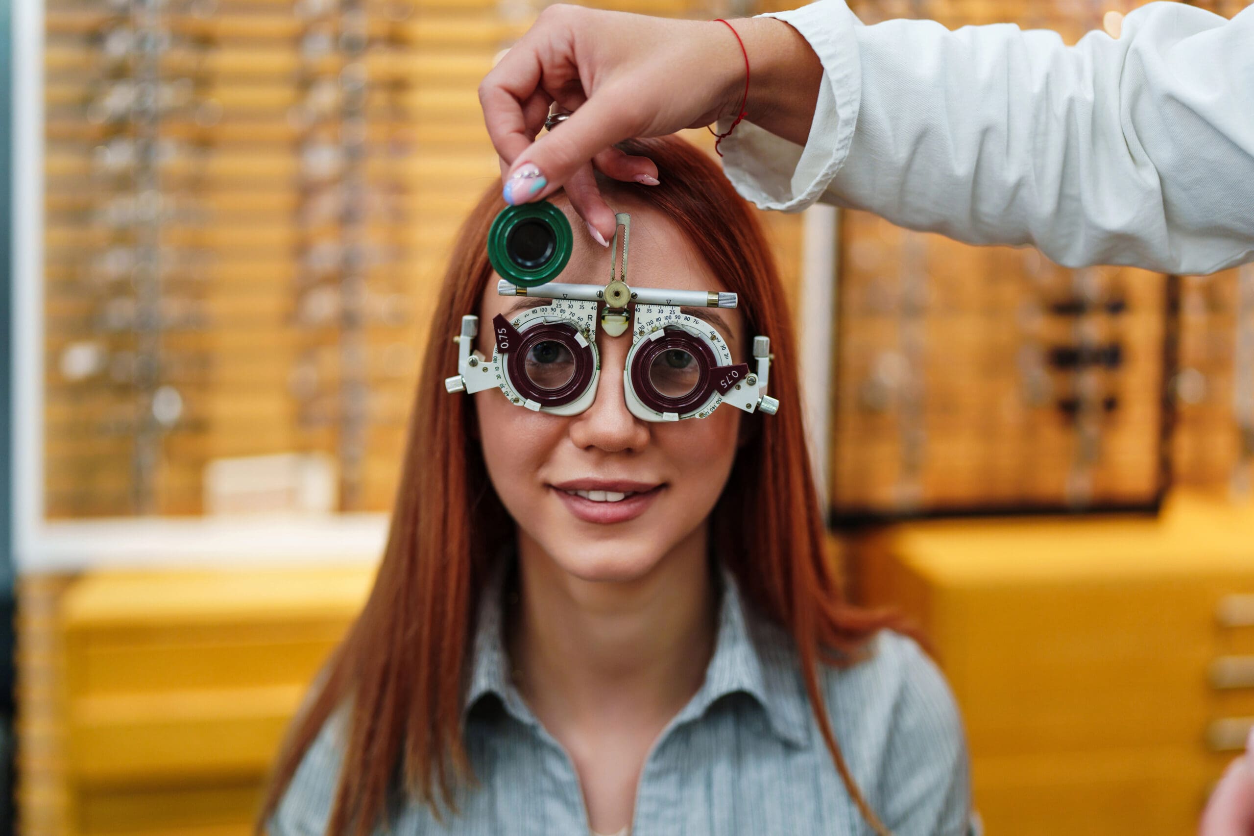 Girl having eyes examined with optometric equipment Maple Grove Eye Doctors at Pearle Vision
